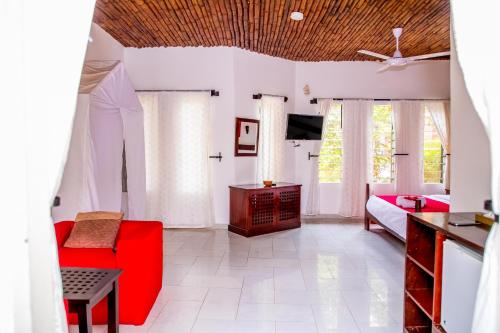 a living room with a red couch and a table at Hibiscus House Gambia in Brufut