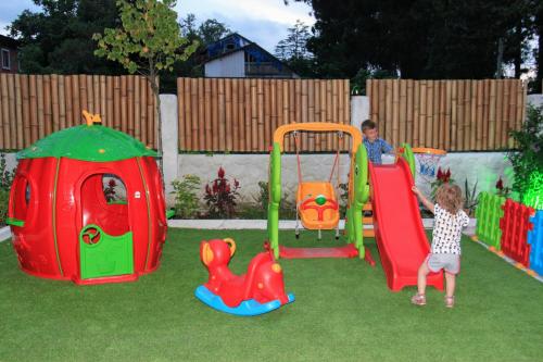 a little girl playing on a playground in a backyard at Hotel Ritsa in Ureki