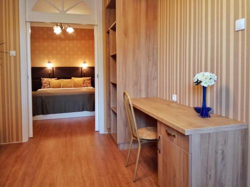 a room with a desk with a bed in the background at Károlyi Panzió in Eger