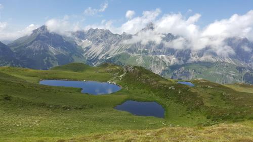two lakes on a hill with mountains in the background at Hotel Montjola Nova in Schruns-Tschagguns