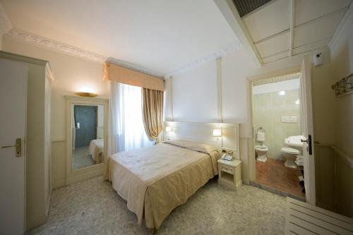 a bedroom with a bed and a bathroom with a toilet at Mancini Park Hotel in Mostacciano 