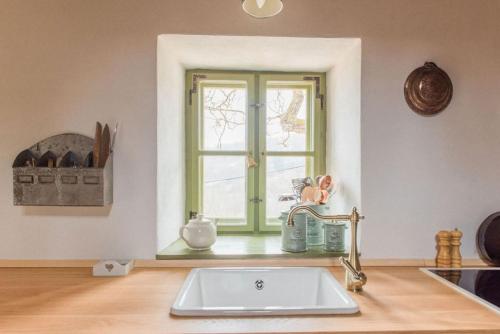 a kitchen with a sink and a window at Nebo nad Štiavnicou - zelená chalupa s výhľadom in Banská Štiavnica