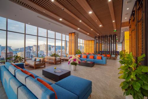 a large lobby with blue couches and windows at G8 Luxury Hotel and Spa Da Nang in Da Nang