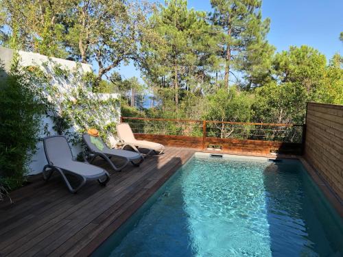 a deck with a swimming pool and two chairs next to it at Residence Mare e Monte in Favone