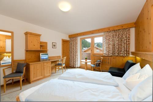a bedroom with a bed and a desk with a computer at S`Hoamatl in Obergurgl