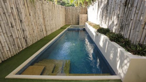 a small swimming pool in a backyard with a wooden fence at Treetop Suites in Coron