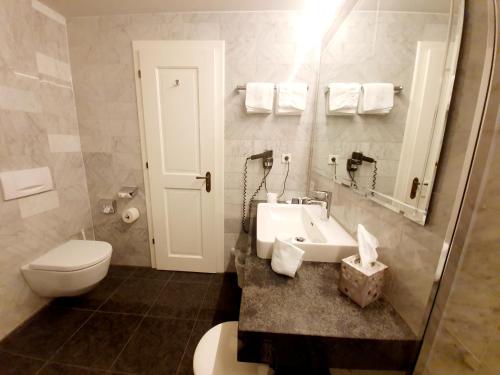 a bathroom with a white sink and a toilet at Landgasthof "Wilder Mann" in Innsbruck