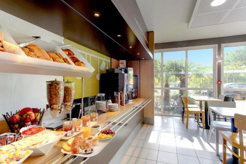a kitchen with a counter with food on it at B&B HOTEL Valenciennes Marly in Marly