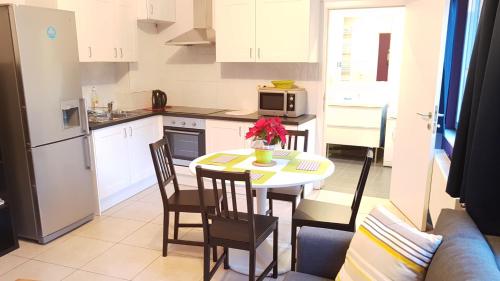 una pequeña cocina con mesa y sillas en una habitación en Apartment Chez Esmara et Philippe, en Bruselas