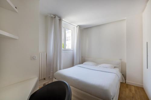 une chambre blanche avec un lit et une fenêtre dans l'établissement Veeve - Crisp Whites in the 16th, à Paris