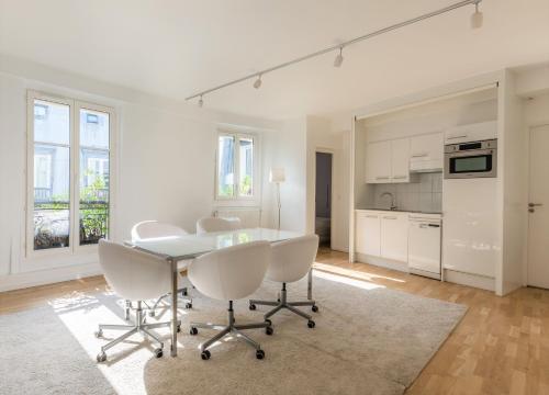 une cuisine et une salle à manger avec une table et des chaises dans l'établissement Veeve - Crisp Whites in the 16th, à Paris