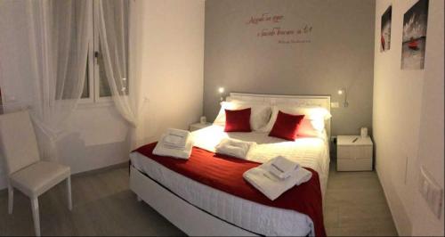 ein Schlafzimmer mit einem Bett mit roten Kissen und einem Stuhl in der Unterkunft I Quattro Elementi in Marina di Mancaversa
