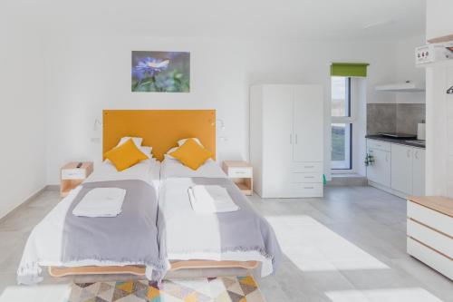 a bedroom with a large bed with yellow pillows at Żabi Staw in Supraśl