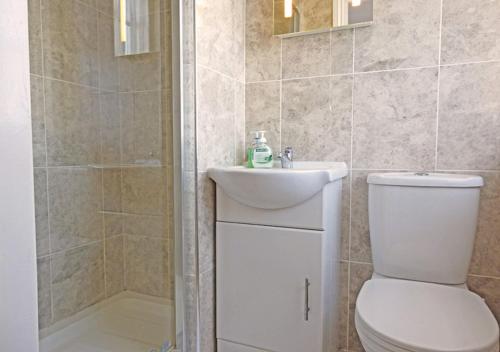 e bagno con servizi igienici, lavandino e doccia. di Bury Villa - 7 bedrooms sleeping 18 guests a Gosport
