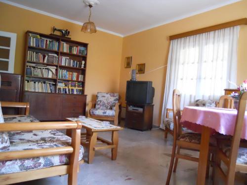 a living room with a tv and a table and chairs at Nicolas Dream in Nea Makri