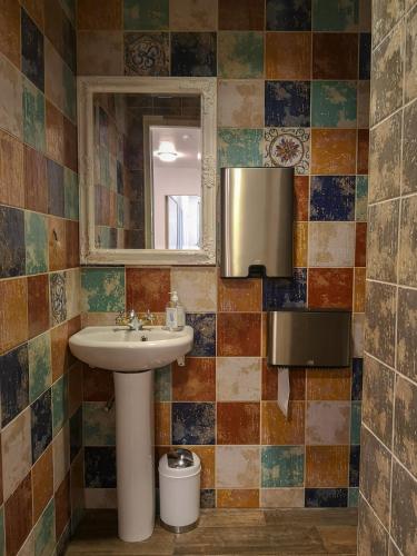 un baño con lavabo y espejo en Villa Kadriorg Hostel, en Tallin