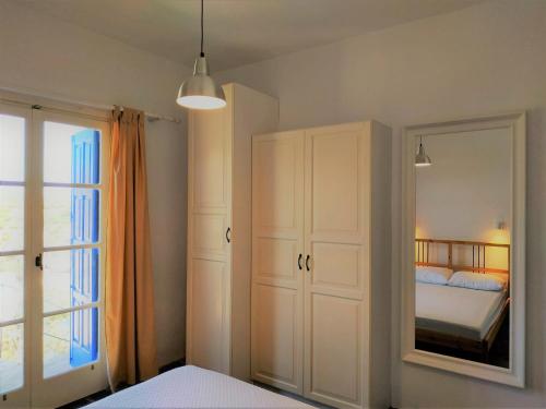a bedroom with a bed and a mirror at Vitali Beach Houses in Andros