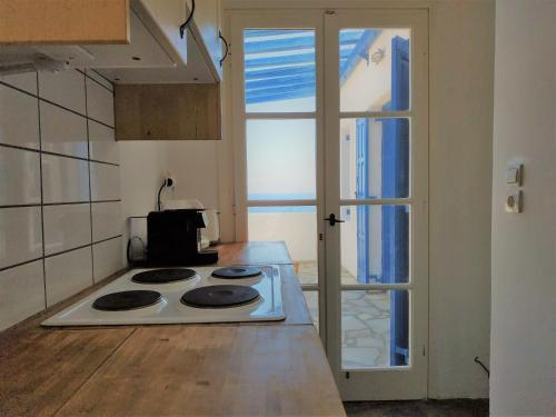 a kitchen with a white stove top oven next to a window at Vitali Beach Houses in Andros