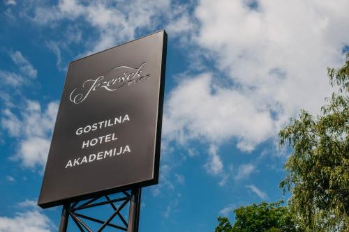 a sign for a hotel with the sky in the background at Hotel Dvor Jezersek Brnik in Cerklje na Gorenjskem