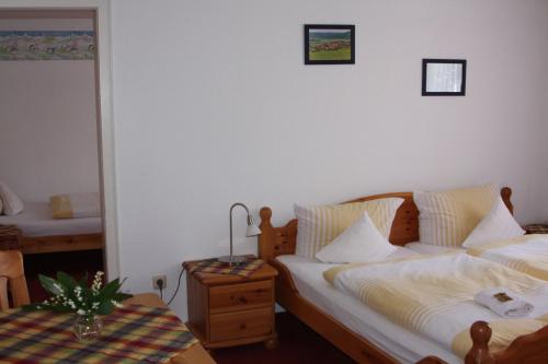 a bedroom with two beds and a table with a lamp at Ferienhof Koch in Oedelsheim