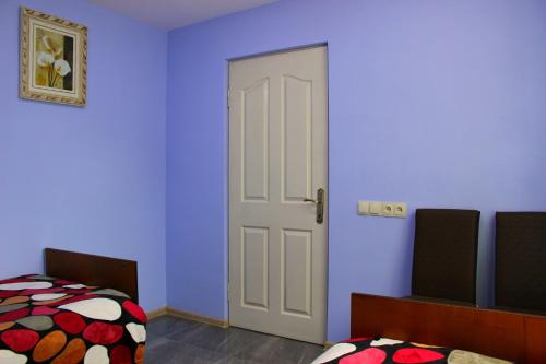 a bedroom with blue walls and a door with a bed at Guest House "Oasis" in Khulo