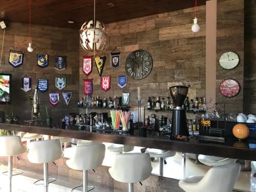 a bar in a restaurant with clocks on the wall at Hotel Levadia in Levádeia