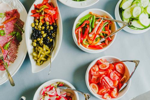 a table topped with bowls of different types of food at Hotel Willa Flora in Szczecin