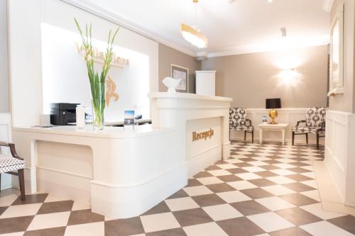 a salon with a reception counter and a checkered floor at Hotel Willa Flora in Szczecin
