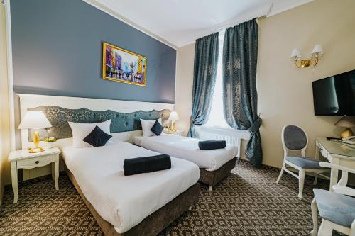 a hotel room with two beds and a television at Hotel Willa Flora in Szczecin