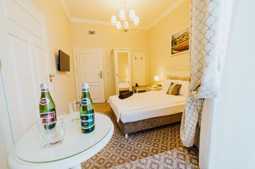 a hotel room with a bed and two bottles on a table at Hotel Willa Flora in Szczecin