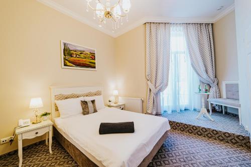 a bedroom with a large bed and a chandelier at Hotel Willa Flora in Szczecin