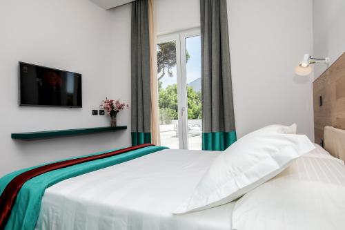 um quarto com uma cama branca e uma janela em Il San Cristoforo em Ercolano