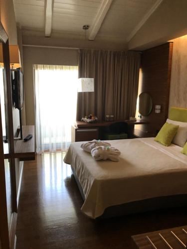 a hotel room with a bed and a large window at Hotel Levadia in Levádeia