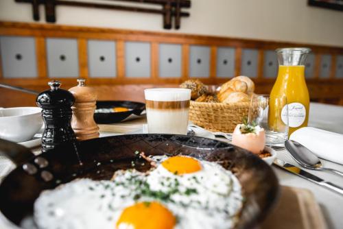 a table with a frying pan with eggs on it at Hotel Dvor Jezersek Brnik in Cerklje na Gorenjskem