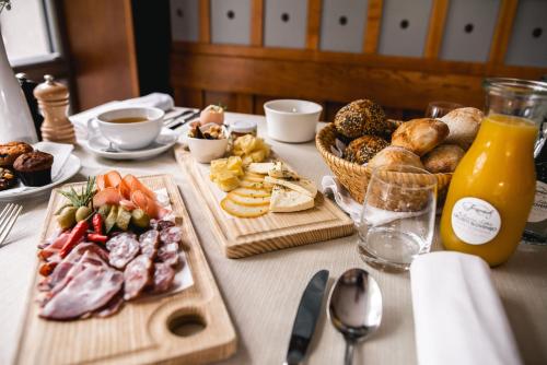 a table topped with plates of food and bread at Hotel Dvor Jezersek Brnik in Cerklje na Gorenjskem
