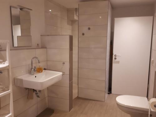 Baño blanco con lavabo y aseo en Villa Wasser, en Hörstel