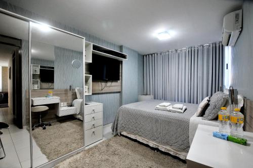 a bedroom with a bed and a sink and a mirror at Elza's Appartament in João Pessoa