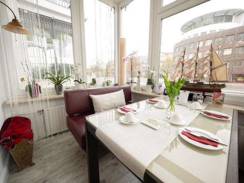 a living room with a table and a boat in the window at Hotel Boritzka in Hamburg