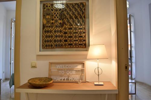 een hal met een tafel met een lamp en een foto bij Apartamento Santos 7 in Málaga
