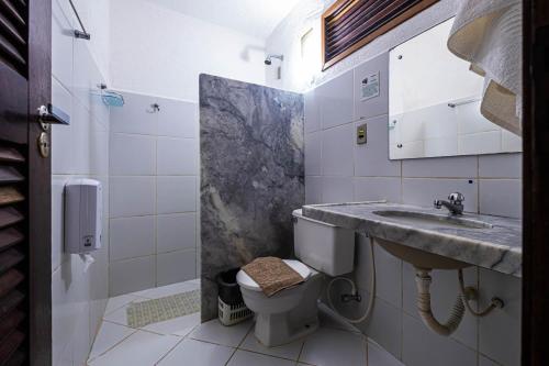 uma casa de banho com um lavatório e um WC em Pousada Villa do Sol em Genipabu