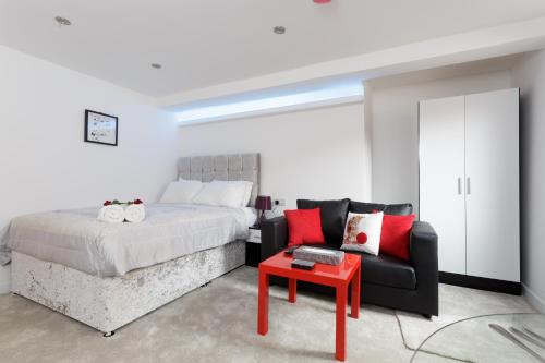 ein Schlafzimmer mit einem Bett, einem Sofa und einem Tisch in der Unterkunft Clifton Bespoke Serviced Apartments in Leeds