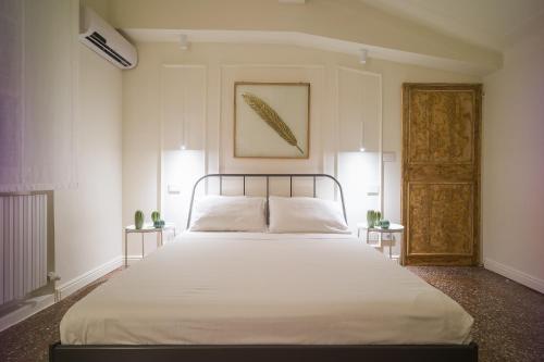 a bedroom with a large white bed with two tables at Luxury Apartment in Palazzo Spada in Bologna