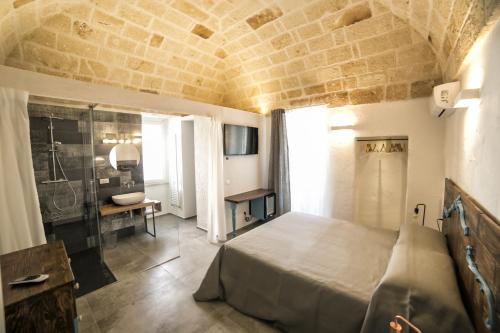 a bedroom with a large bed and a bathroom at Palazzo Murat B&B in Monopoli