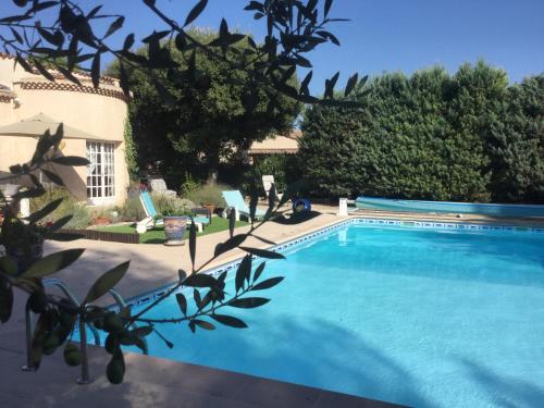 a swimming pool in front of a house at Le Patio Fleuri in Lorgues