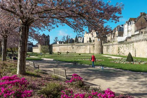a person walking a dog in front of a castle at Appartements de caractère centre in Vannes