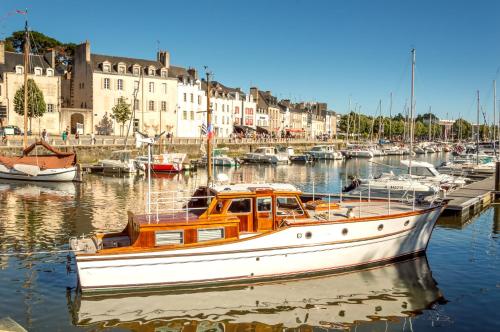 a boat is docked in a harbor with buildings at Appartements de caractère centre in Vannes