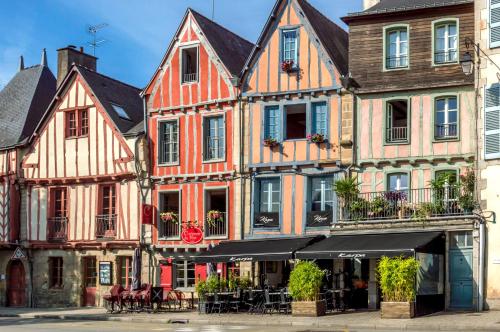 a group of buildings with tables and chairs on a street at Appartements de caractère centre in Vannes