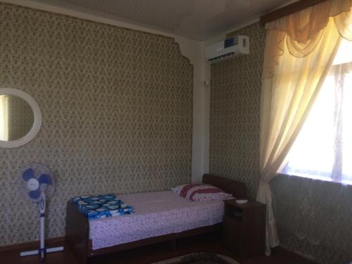 a small bedroom with a small bed and a window at Guesthouse at Oleg's Zolotoy Bereg in Gudauta