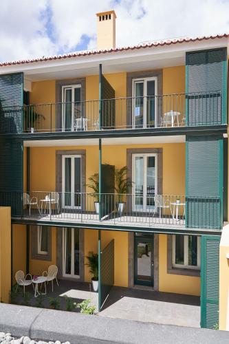 an apartment building with tables and chairs on the balconies at Good Memories Lodge in Funchal