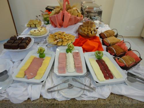 グアラプアバにあるHotel Dom Baroniのさまざまな種類の食べ物が並んだテーブル
